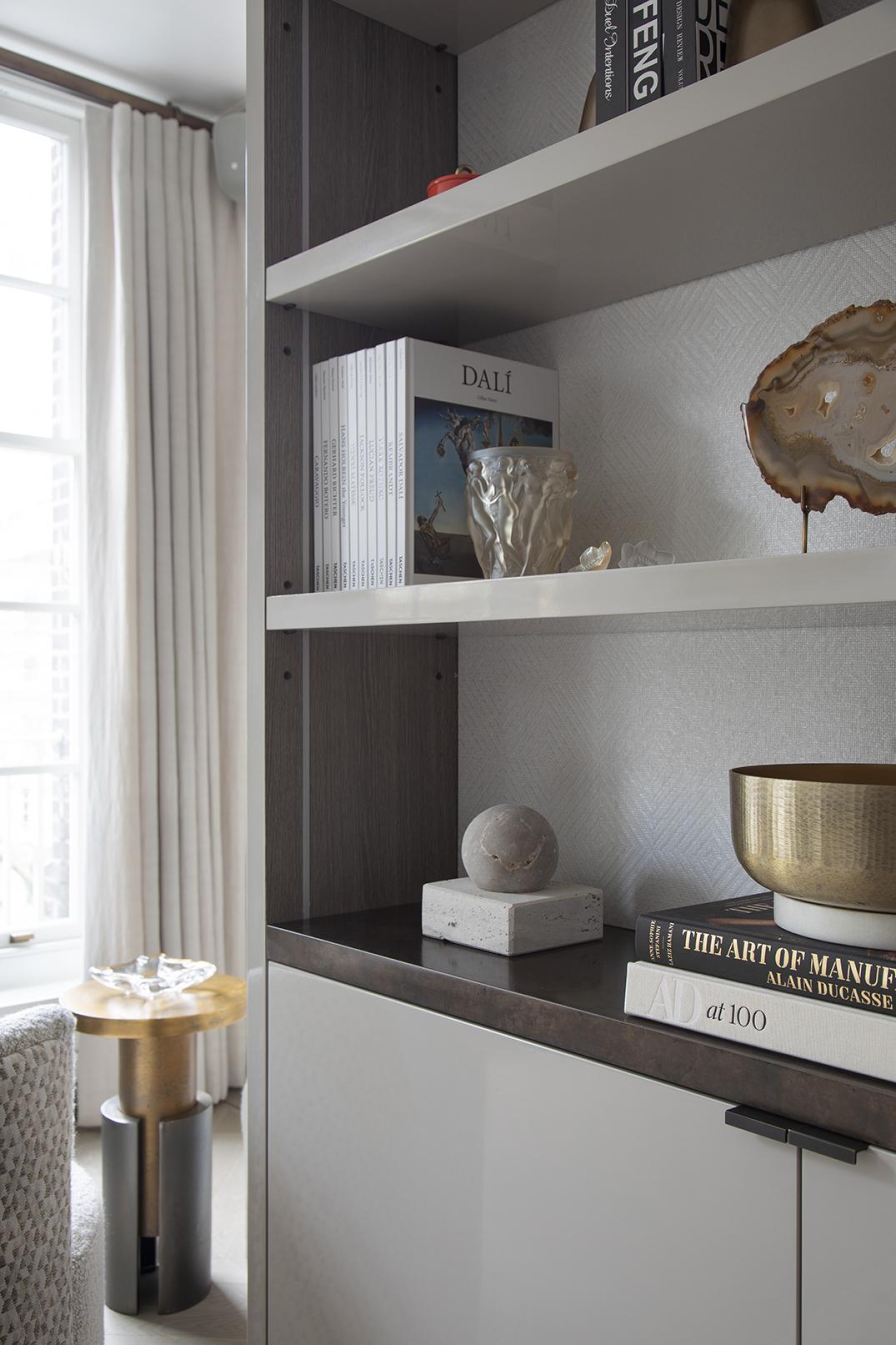 Bespoke alcove shelving with integrated lighting and books in a London home